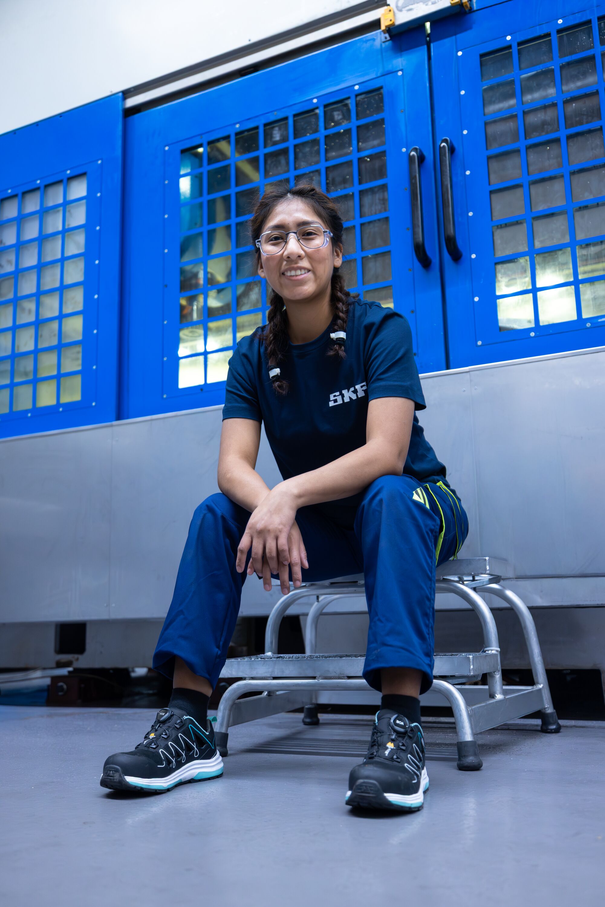 Profissional da SKF sentada em frente a uma máquina industrial