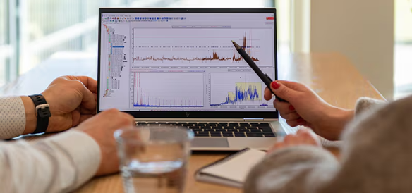 Equipe analisando gráficos de vibração em um notebook